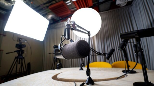 Empty podcast studio with microphones, chairs and lights