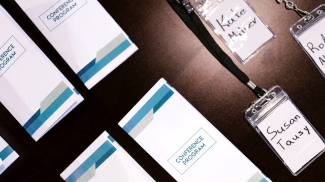 Name badges and printed programmes laid out on a table before an event