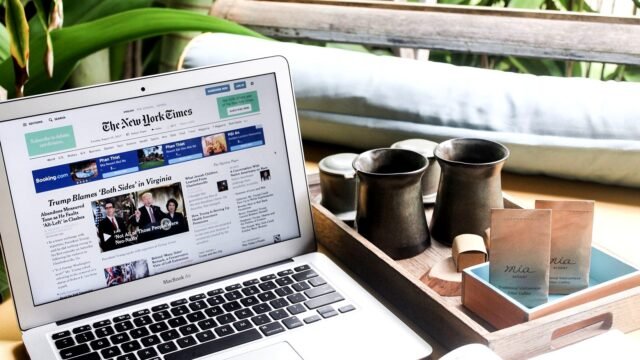 An open laptop on a table showing a news website