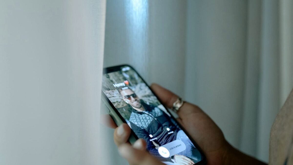 Hand holding a smartphone with an incoming call on screen