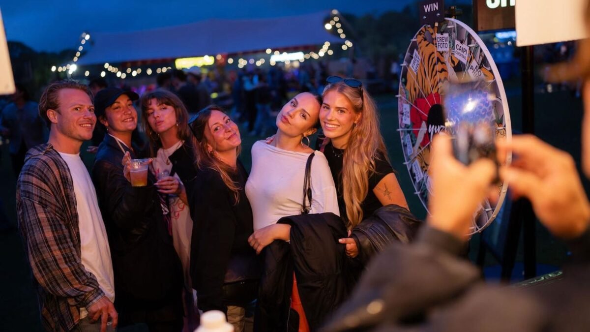 Festival fans posing for a photo next to an Innercrowd prize wheel at Crave Festival