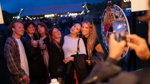 Festival fans posing for a photo next to an Innercrowd prize wheel at Crave Festival