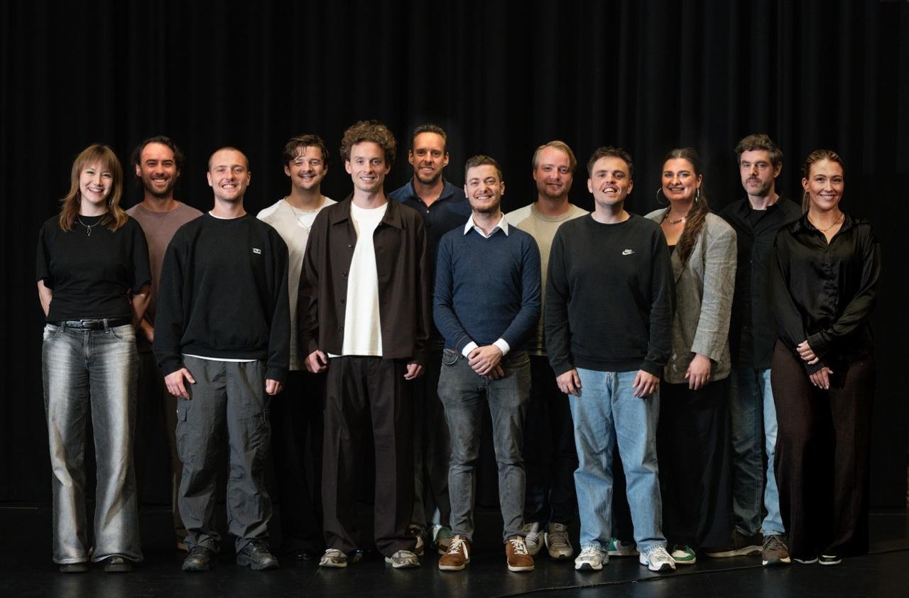 The Innercrowd team, twelve people standing in front of a black curtain