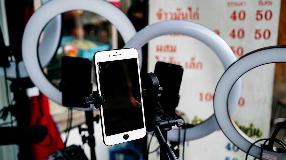 Smartphone on a tripod between ring lights in a small video studio