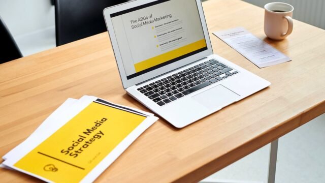 A laptop screen shows a social media marketing dashboard