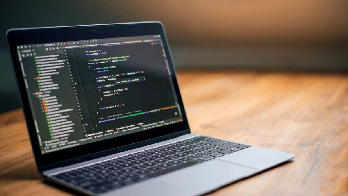 Laptop on a wooden desk showing website code
