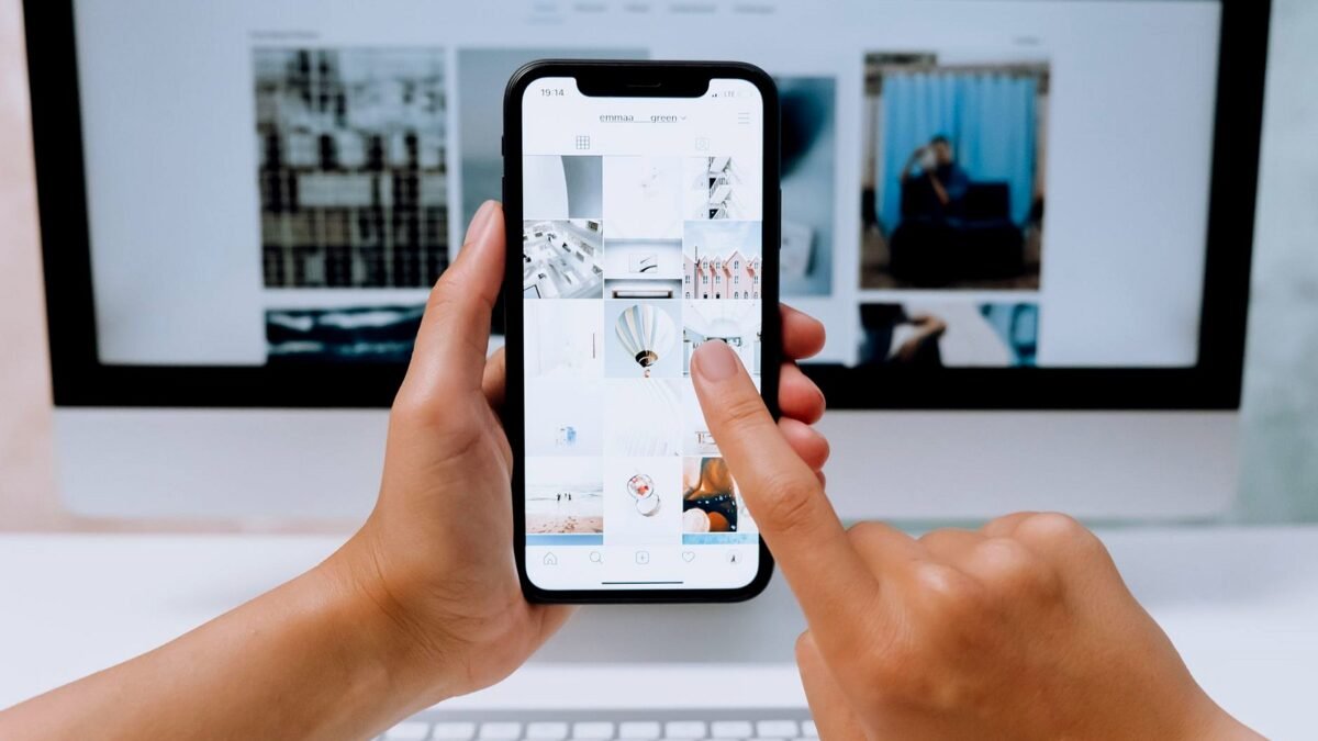 Hands holding a smartphone with a social media feed on screen