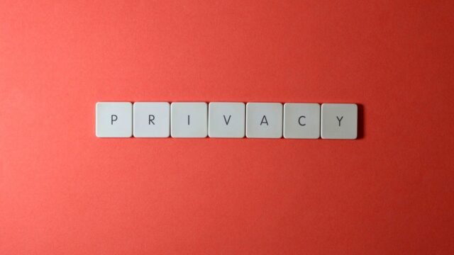 Letter tiles spelling the word privacy on a red background