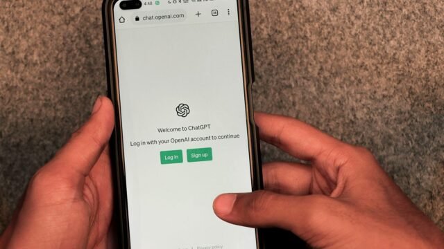 Hands holding a phone with the ChatGPT app open on the screen