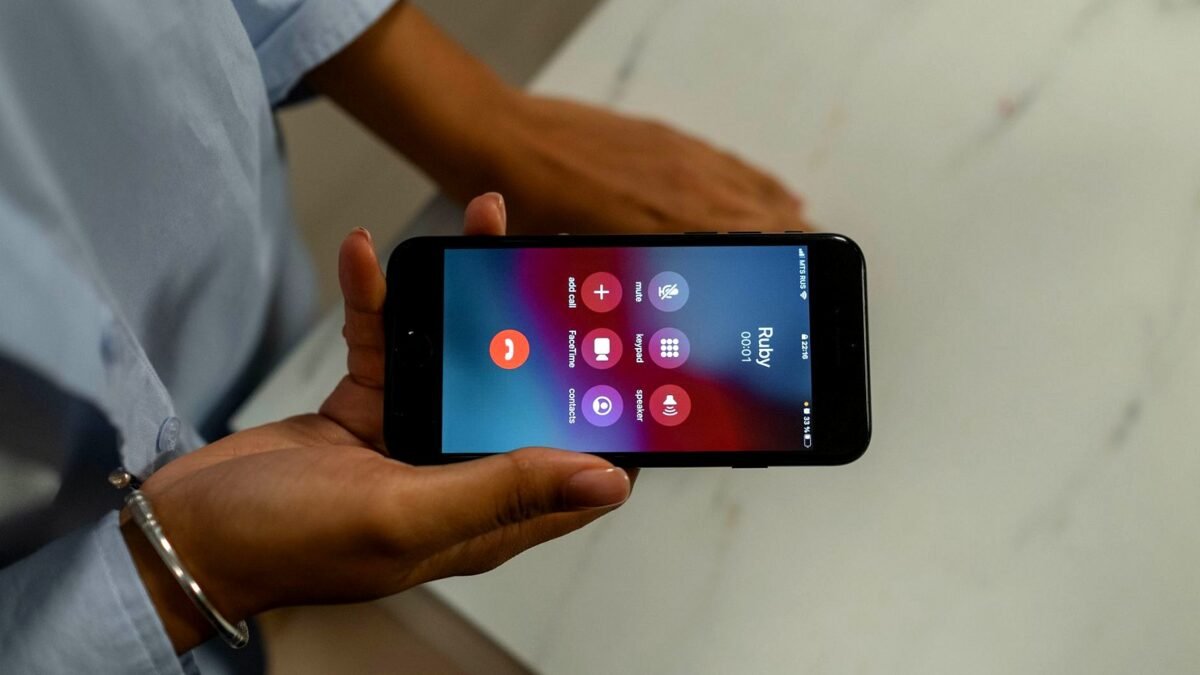 Hand holding a smartphone with an incoming call screen