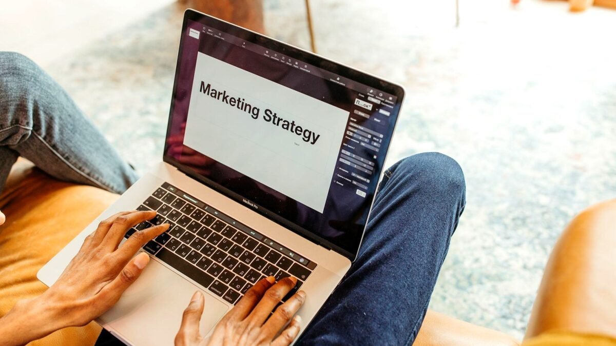 Hands on a laptop showing a marketing strategy slide in an office