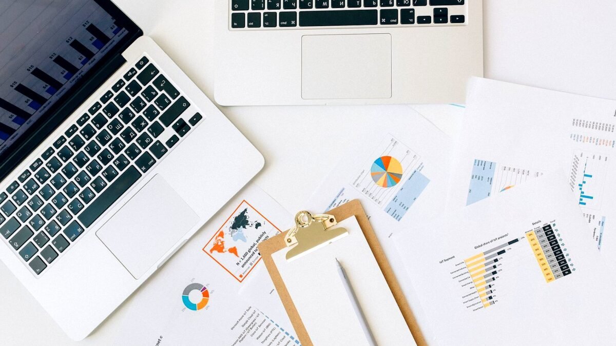 Laptops and printed charts on a desk